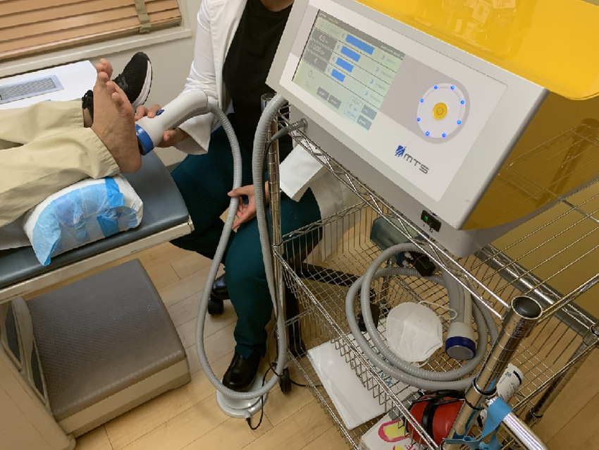 SoftWave OrthoGold100 shockwave device being applied to a patient's foot